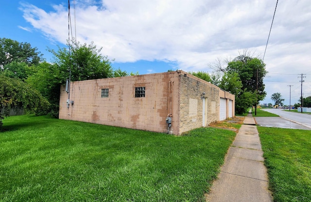 view of side of home with a yard and a garage