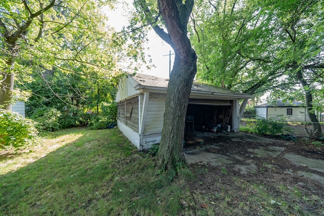 exterior space with an outbuilding, a garage, and a lawn