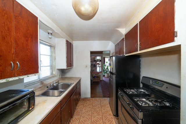 kitchen featuring sink, light hardwood / wood-style flooring, and black appliances