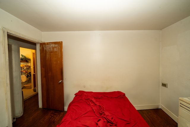 bedroom with dark wood-type flooring