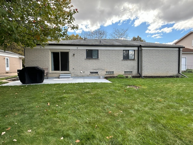 back of property with a lawn and a patio