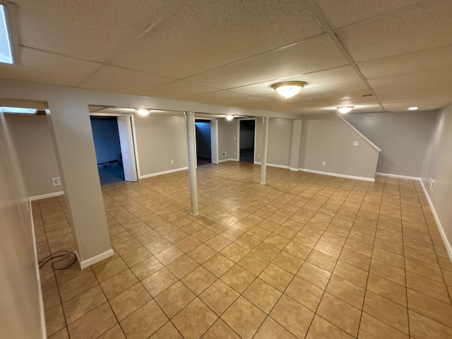 basement with a drop ceiling and light tile patterned floors