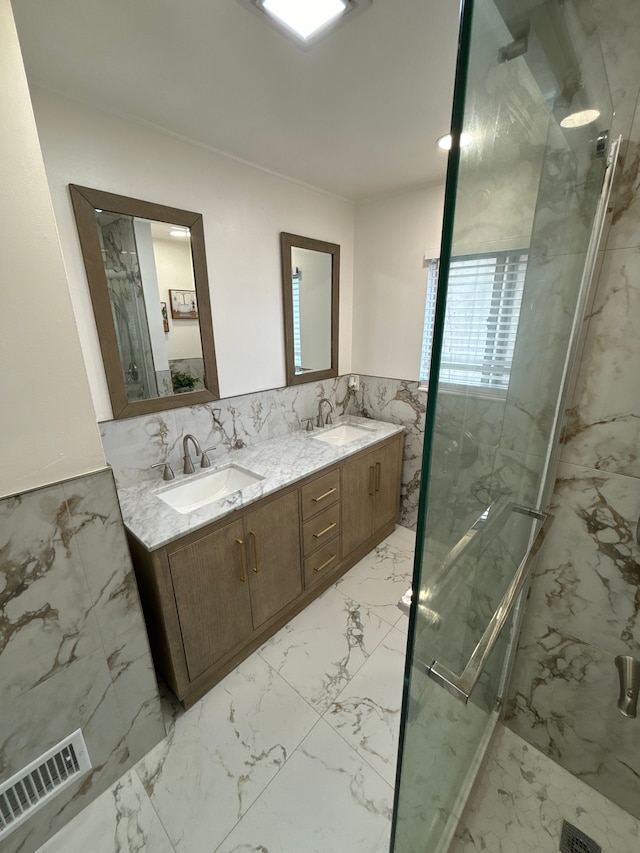 bathroom with vanity, a shower with door, and tile walls