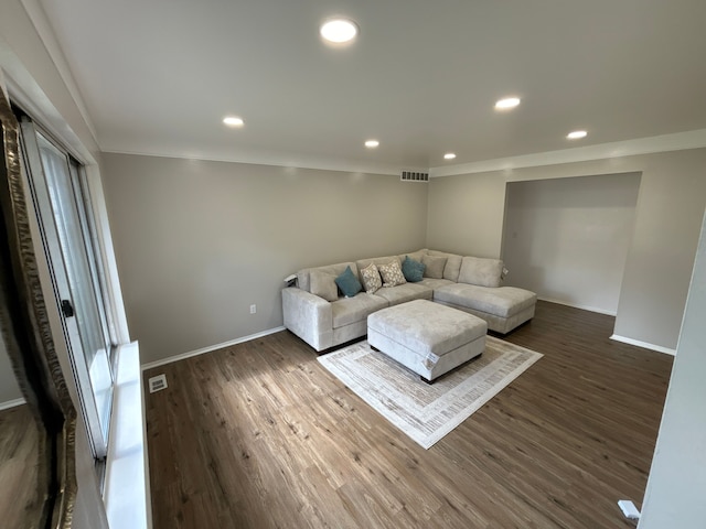 living room with dark hardwood / wood-style flooring and crown molding