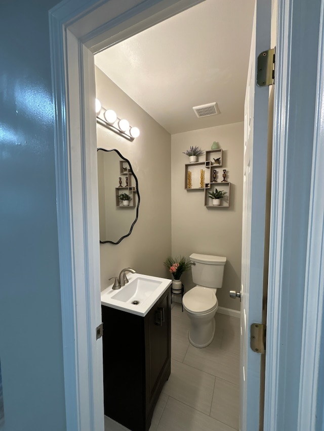 bathroom featuring tile patterned flooring, vanity, and toilet