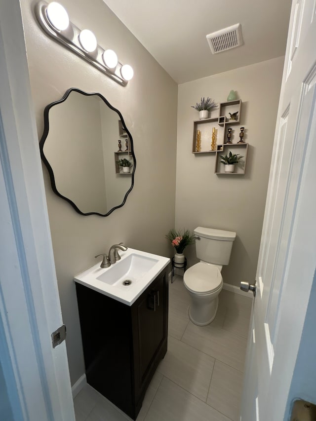 bathroom featuring tile patterned floors, vanity, and toilet