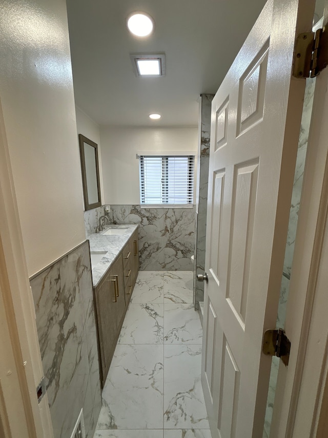 bathroom featuring vanity and tile walls