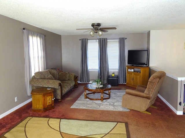 living room with a textured ceiling, dark carpet, and ceiling fan