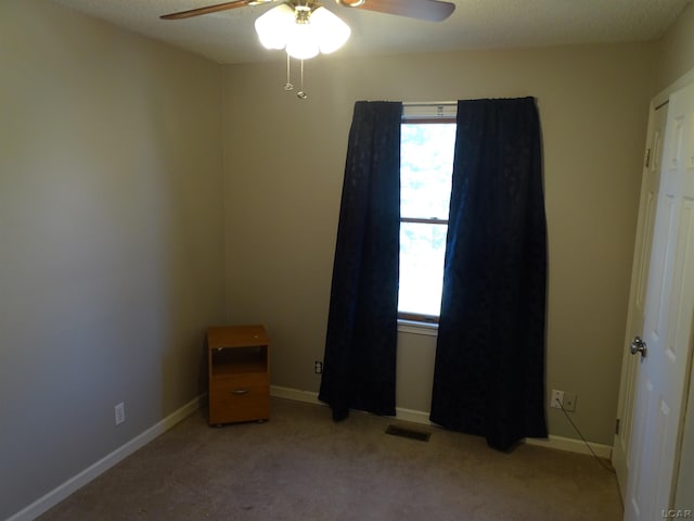 empty room featuring light carpet and ceiling fan