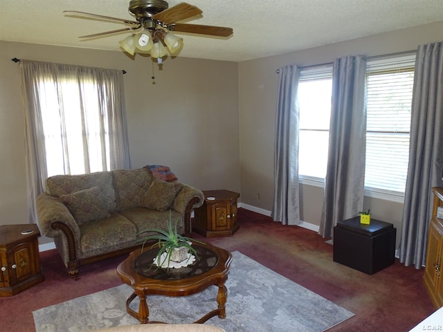 living room with ceiling fan, plenty of natural light, and dark colored carpet