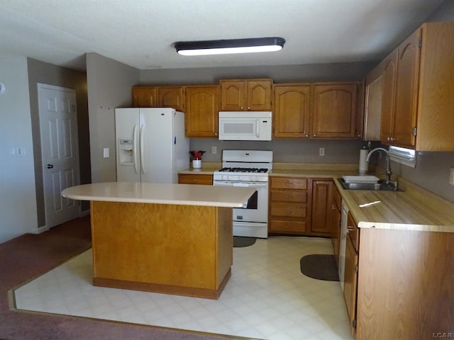 kitchen featuring sink, a center island, and white appliances