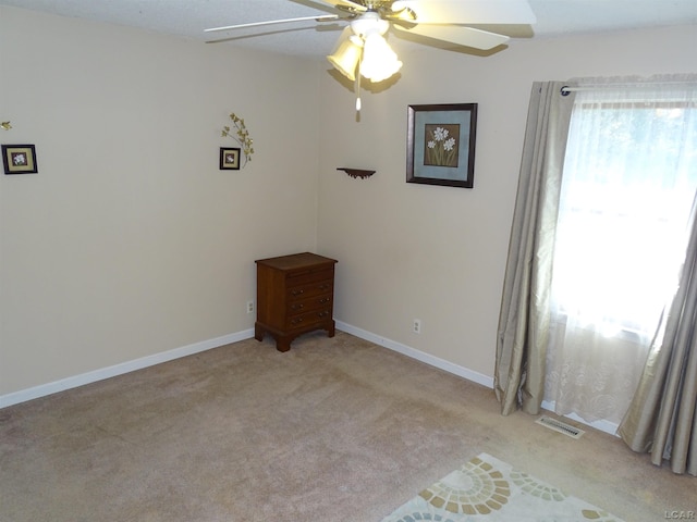 carpeted empty room with ceiling fan and a textured ceiling