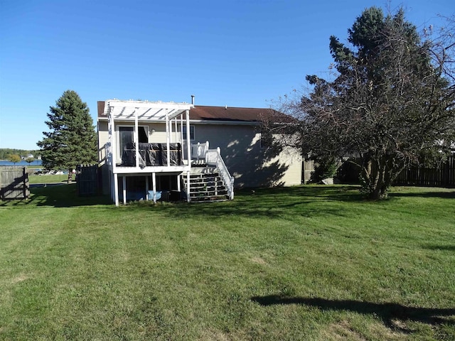 back of house with a pergola, a wooden deck, and a yard