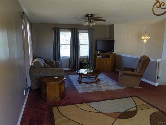 living room with ceiling fan with notable chandelier, dark carpet, and a textured ceiling