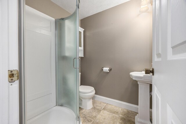 11600 Baker Rd, Greenville, MI 48838 - bathroom featuring a stall shower, toilet, baseboards, tile patterned flooring, and a textured ceiling