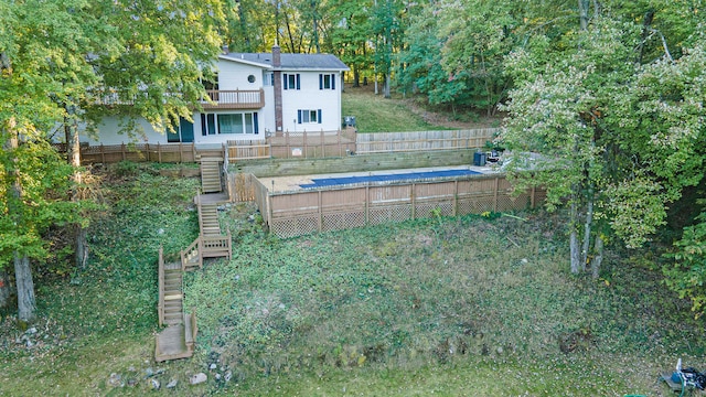view of yard featuring stairway, a fenced backyard, and a balcony