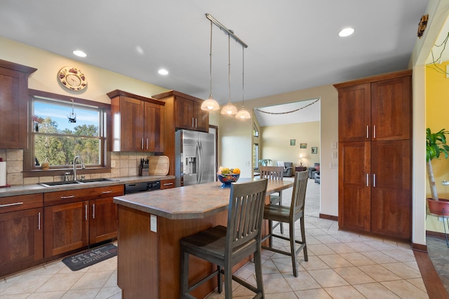 kitchen with a kitchen bar, backsplash, sink, stainless steel fridge with ice dispenser, and a kitchen island