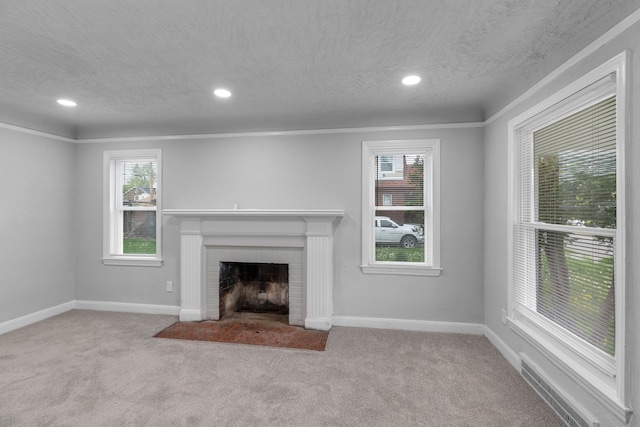 unfurnished living room featuring a textured ceiling, light colored carpet, a brick fireplace, and ornamental molding