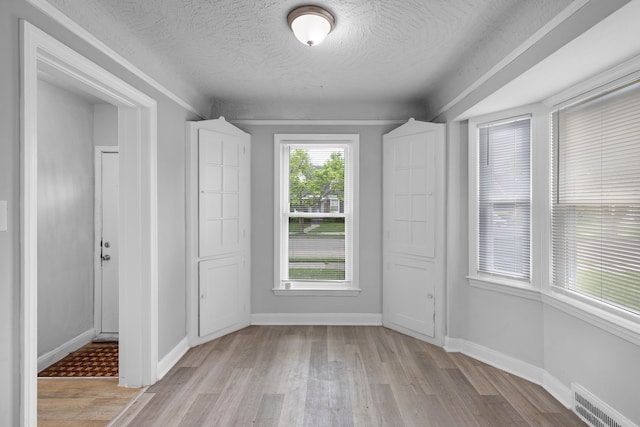 spare room featuring a textured ceiling and light wood-type flooring