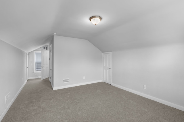 additional living space featuring carpet floors and vaulted ceiling