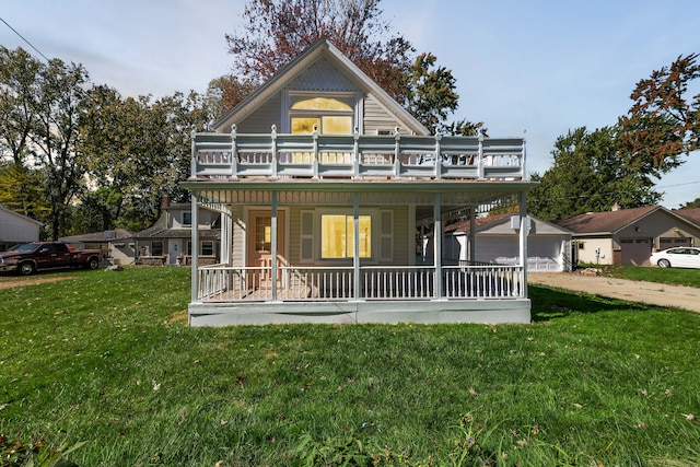 rear view of property featuring a yard, a balcony, and covered porch