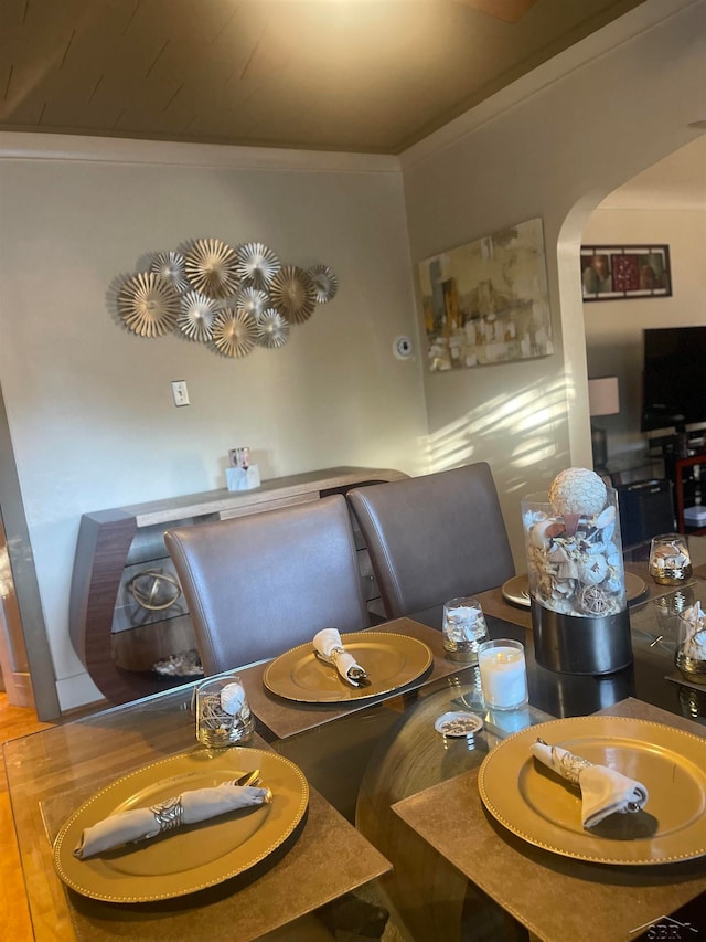 dining space with hardwood / wood-style flooring and ornamental molding