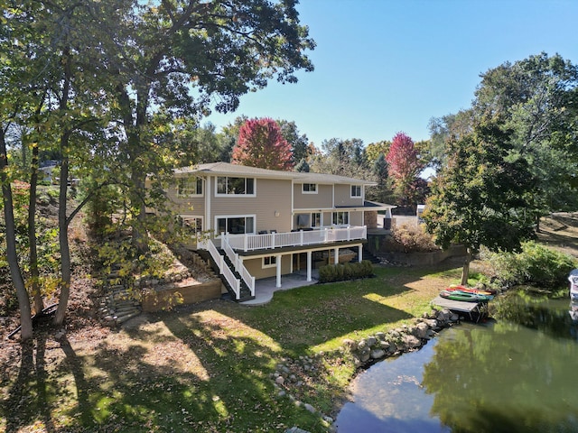 back of house featuring a yard and a deck with water view