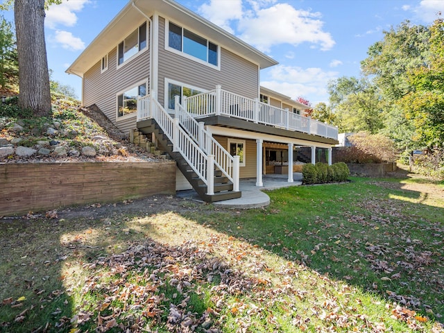 back of house with a patio, a wooden deck, and a lawn