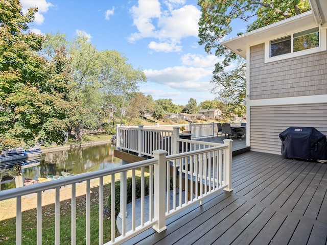 wooden deck featuring area for grilling and a water view