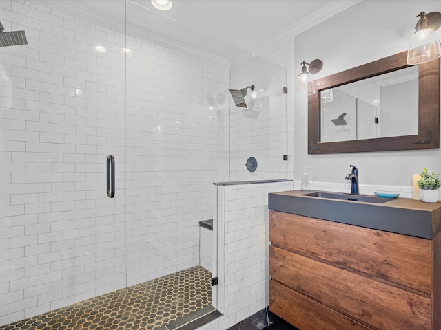 bathroom with vanity, a shower with shower door, and ornamental molding