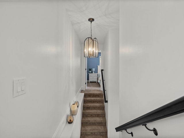 stairs featuring carpet flooring and a notable chandelier