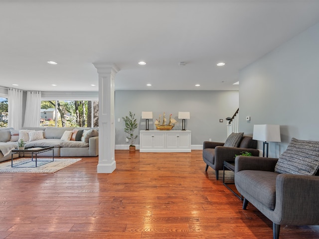 living room with hardwood / wood-style flooring and ornate columns