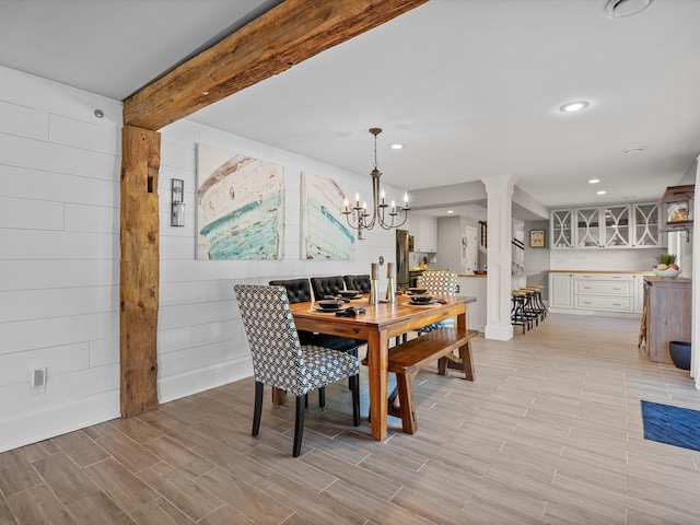 dining area with beamed ceiling and a chandelier