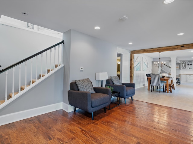 sitting room with hardwood / wood-style flooring and a chandelier