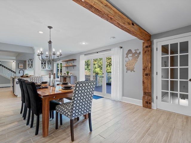 dining room featuring beamed ceiling, a chandelier, and light wood-type flooring