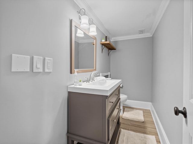 bathroom with vanity, hardwood / wood-style flooring, toilet, and ornamental molding