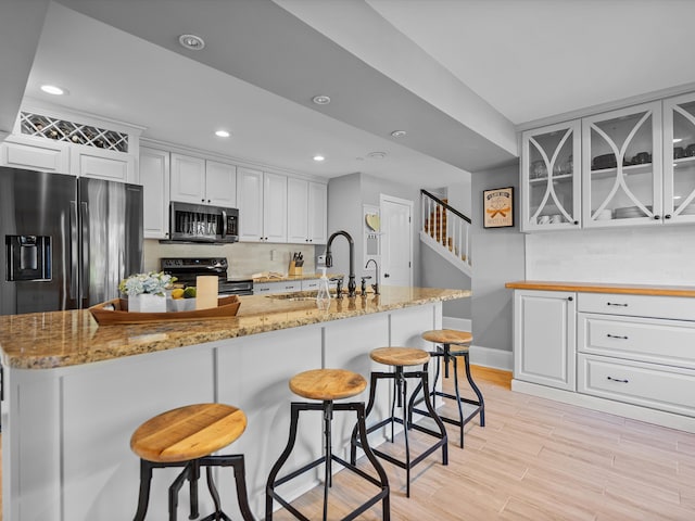 kitchen featuring backsplash, sink, white cabinetry, and stainless steel appliances