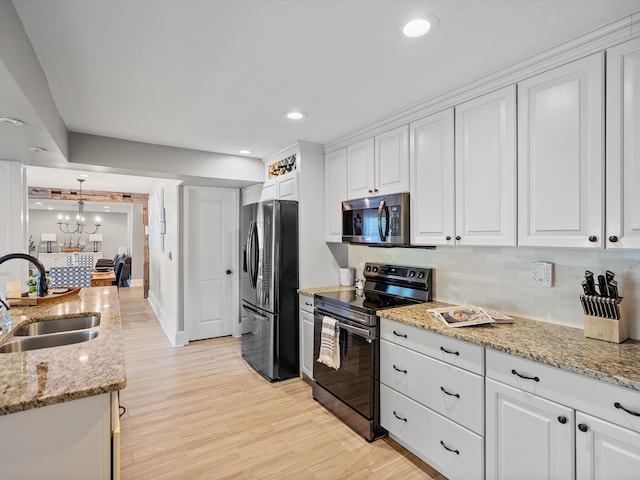 kitchen featuring appliances with stainless steel finishes, light wood-type flooring, white cabinetry, and sink