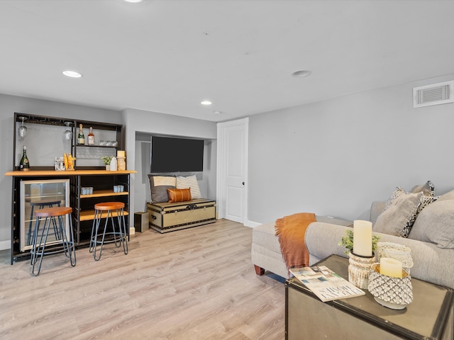 living room featuring light hardwood / wood-style floors and indoor bar