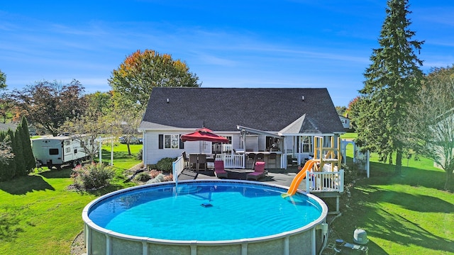 view of swimming pool featuring a lawn and a wooden deck