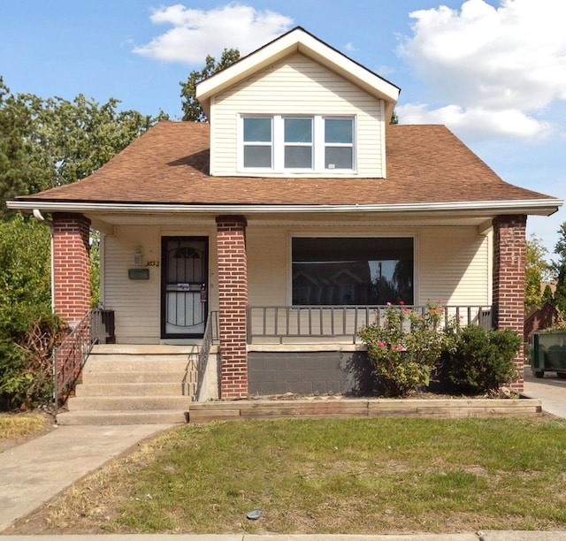 view of front of house with a porch and a front lawn