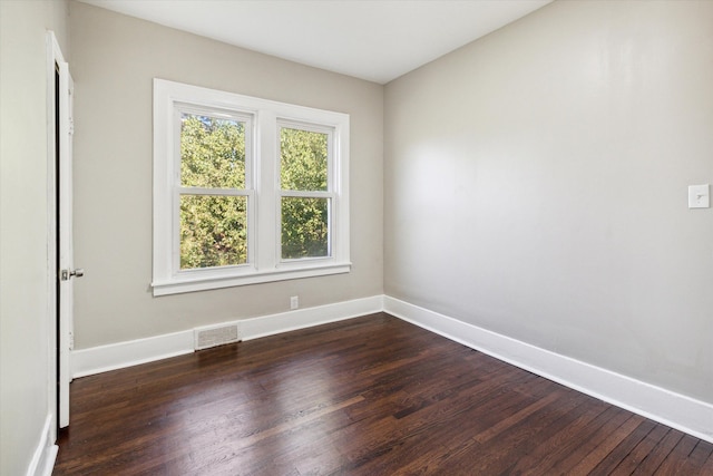 unfurnished room with dark hardwood / wood-style flooring