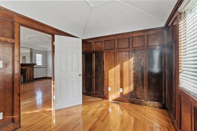 interior space with a textured ceiling, light hardwood / wood-style flooring, and ornamental molding