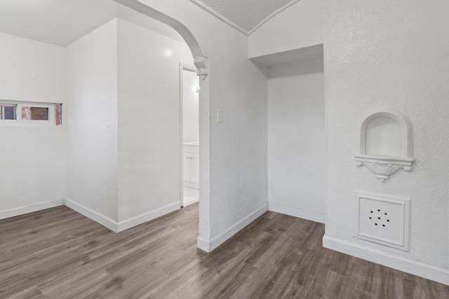 empty room with dark wood-type flooring and vaulted ceiling