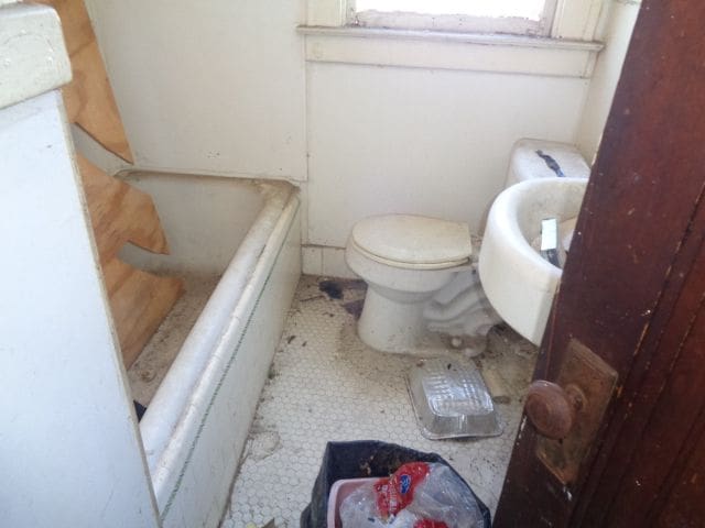 bathroom featuring a bath, toilet, and tile patterned floors