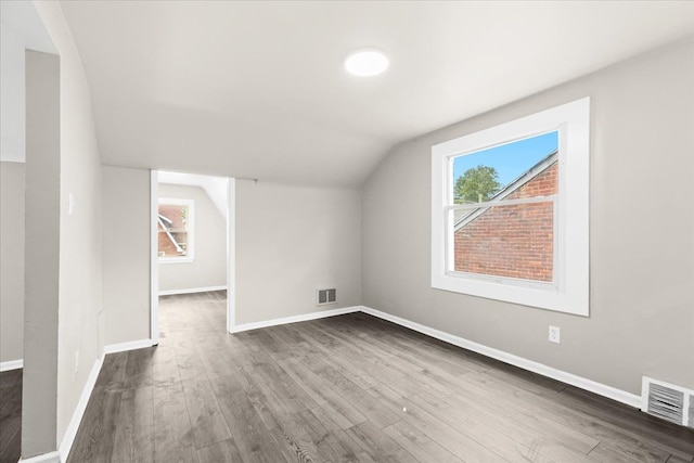 bonus room with dark hardwood / wood-style flooring and lofted ceiling