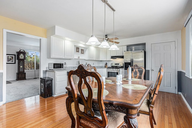 3735 S Portsmouth Rd, Bridgeport, MI 48722 - dining space featuring light wood-style floors, ceiling fan, and a wainscoted wall