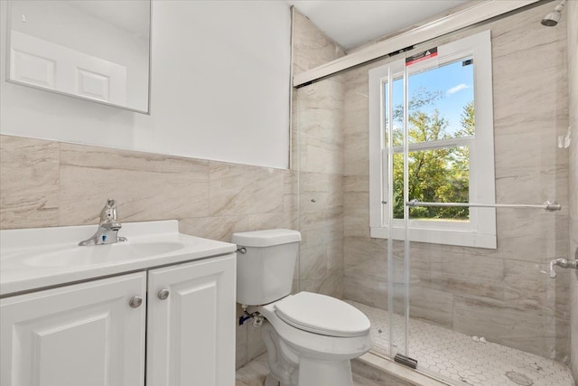 bathroom with vanity, toilet, tile walls, and a healthy amount of sunlight