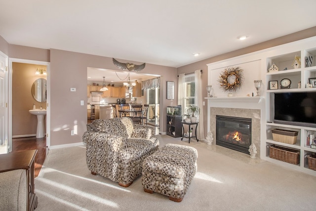 carpeted living room with a notable chandelier