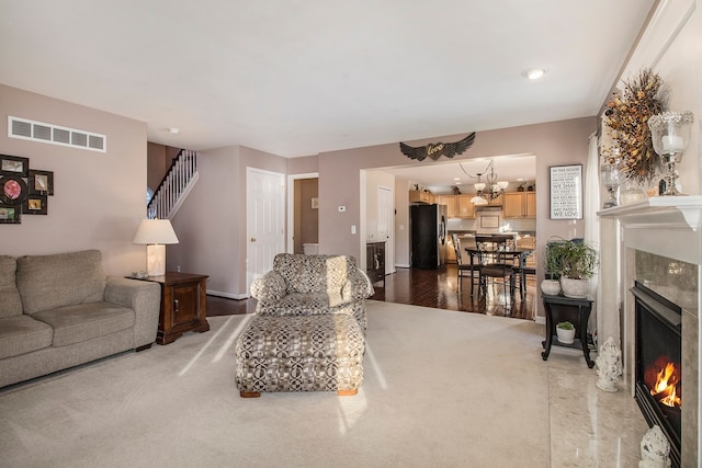 living room featuring a chandelier, hardwood / wood-style flooring, and a premium fireplace